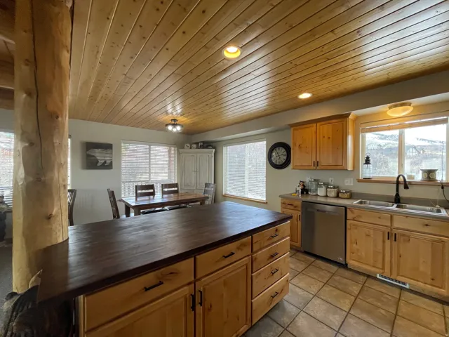 Kitchen with stainless steel dishwasher, wooden ceiling, recessed lighting, plenty of natural light, and light tile patterned floors