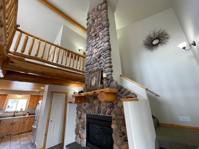 Living room with a stone fireplace and a high ceiling