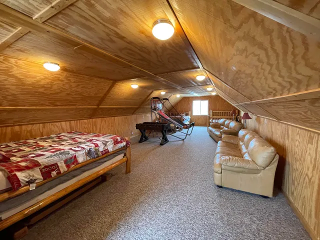 Carpeted bedroom featuring wood walls and wood ceiling
