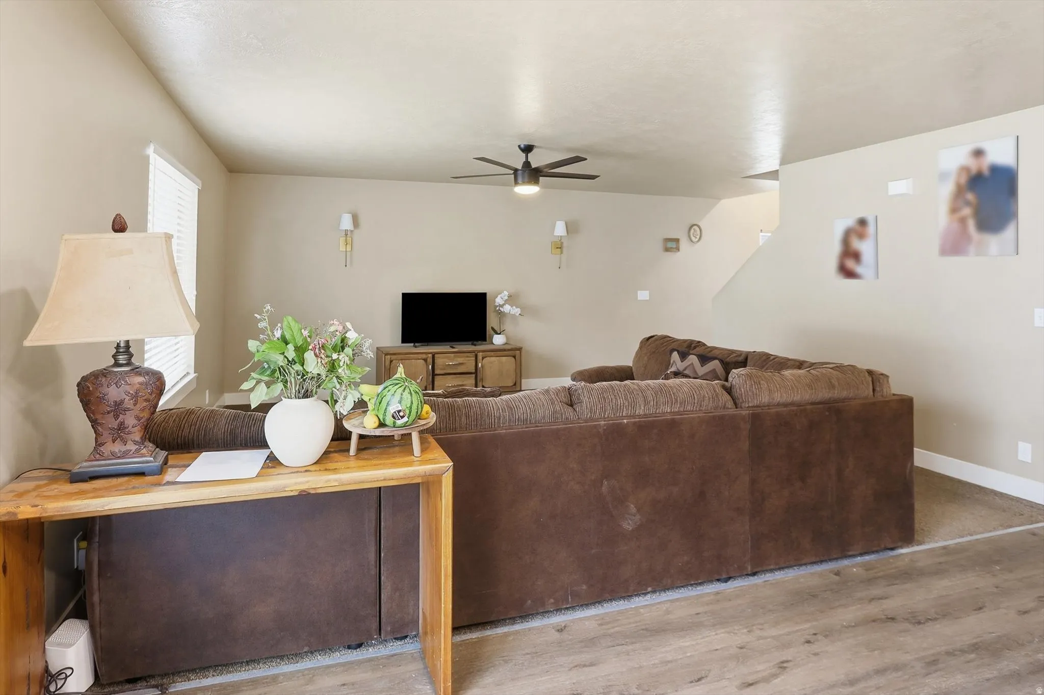 Living room with wood finished floors and a ceiling fan