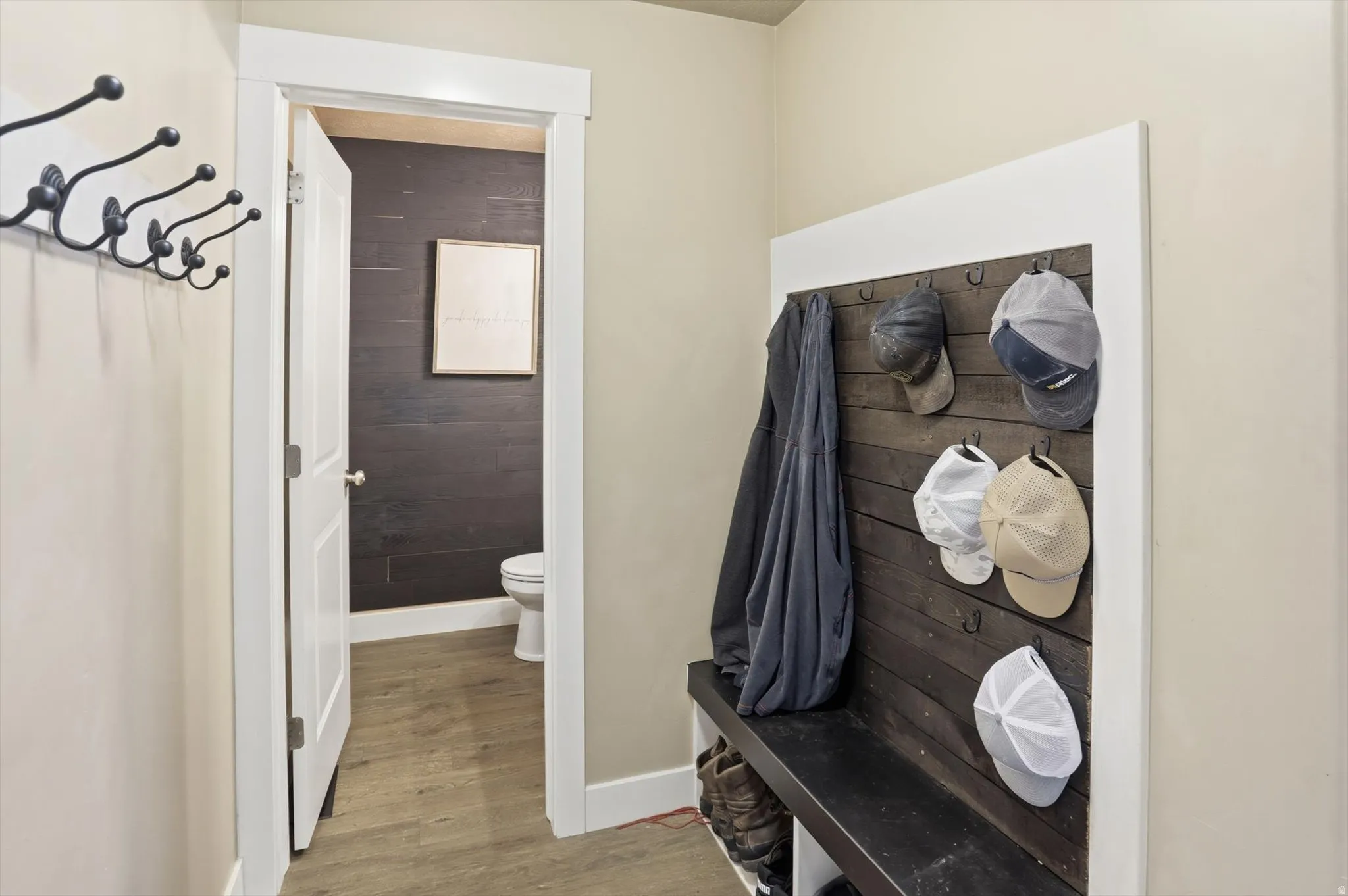 Mudroom with light wood-style flooring and wooden walls