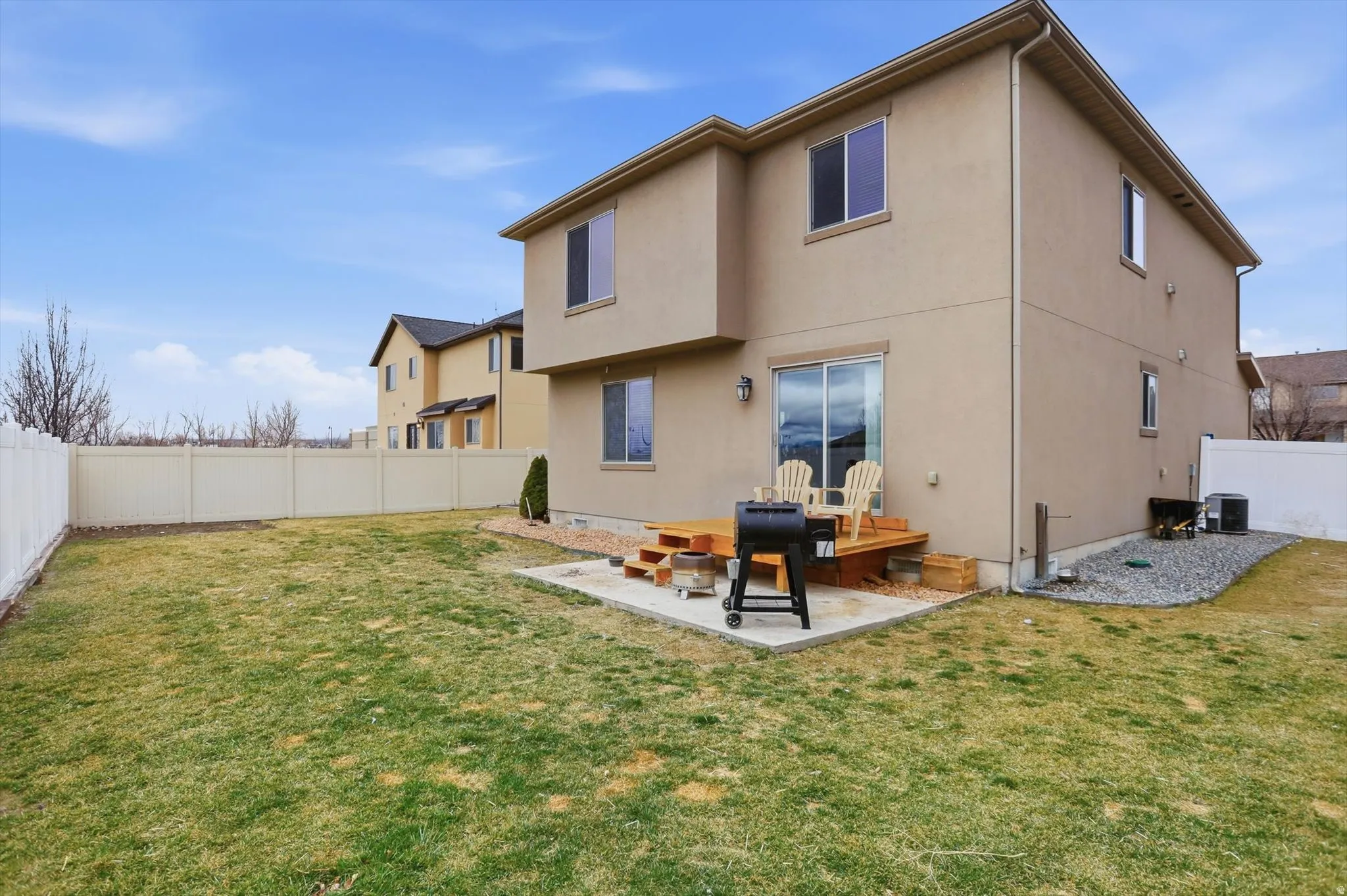 Rear view of house with a patio, a fenced backyard, and stucco siding