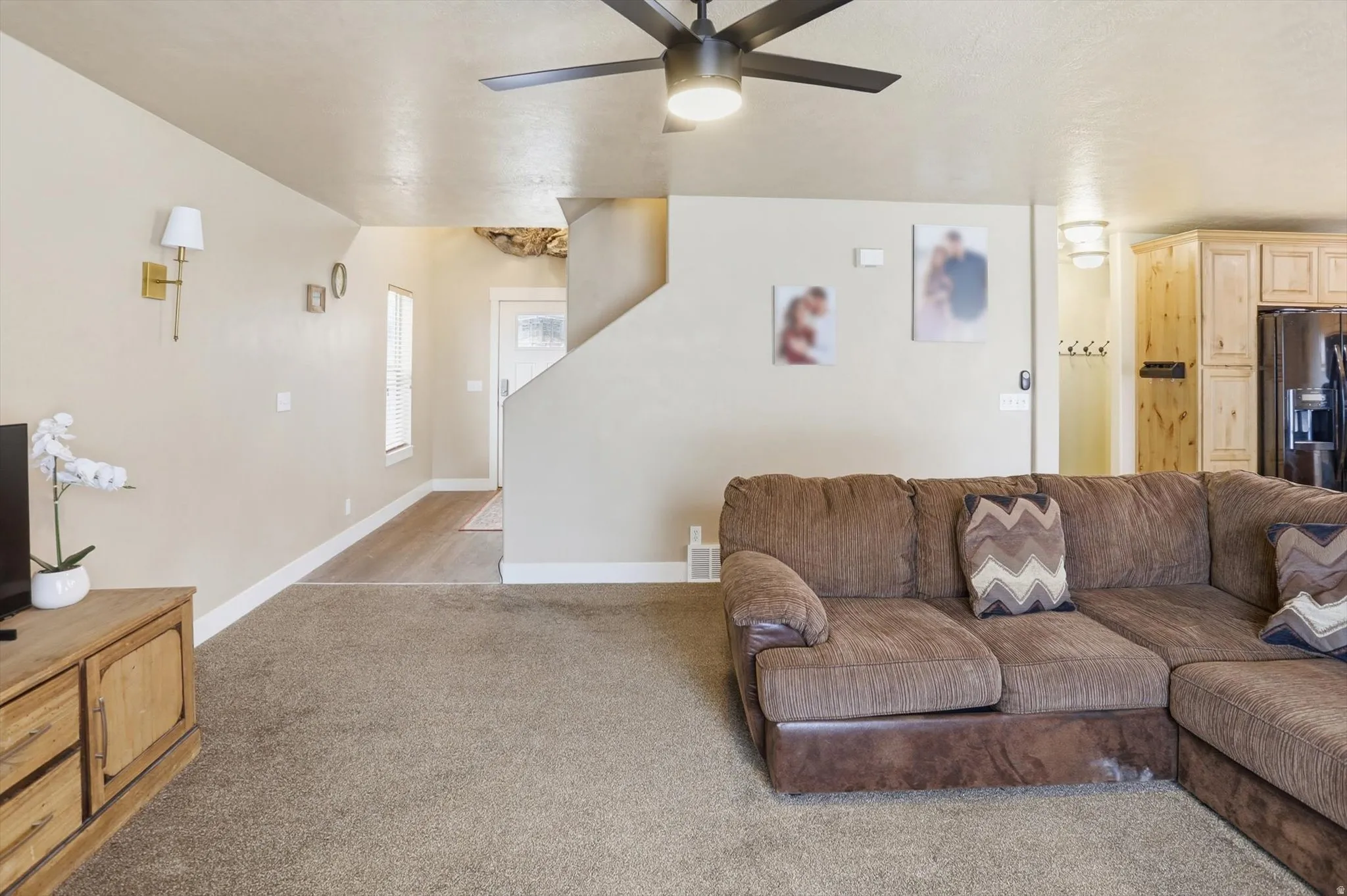 Living room with ceiling fan and light colored carpet