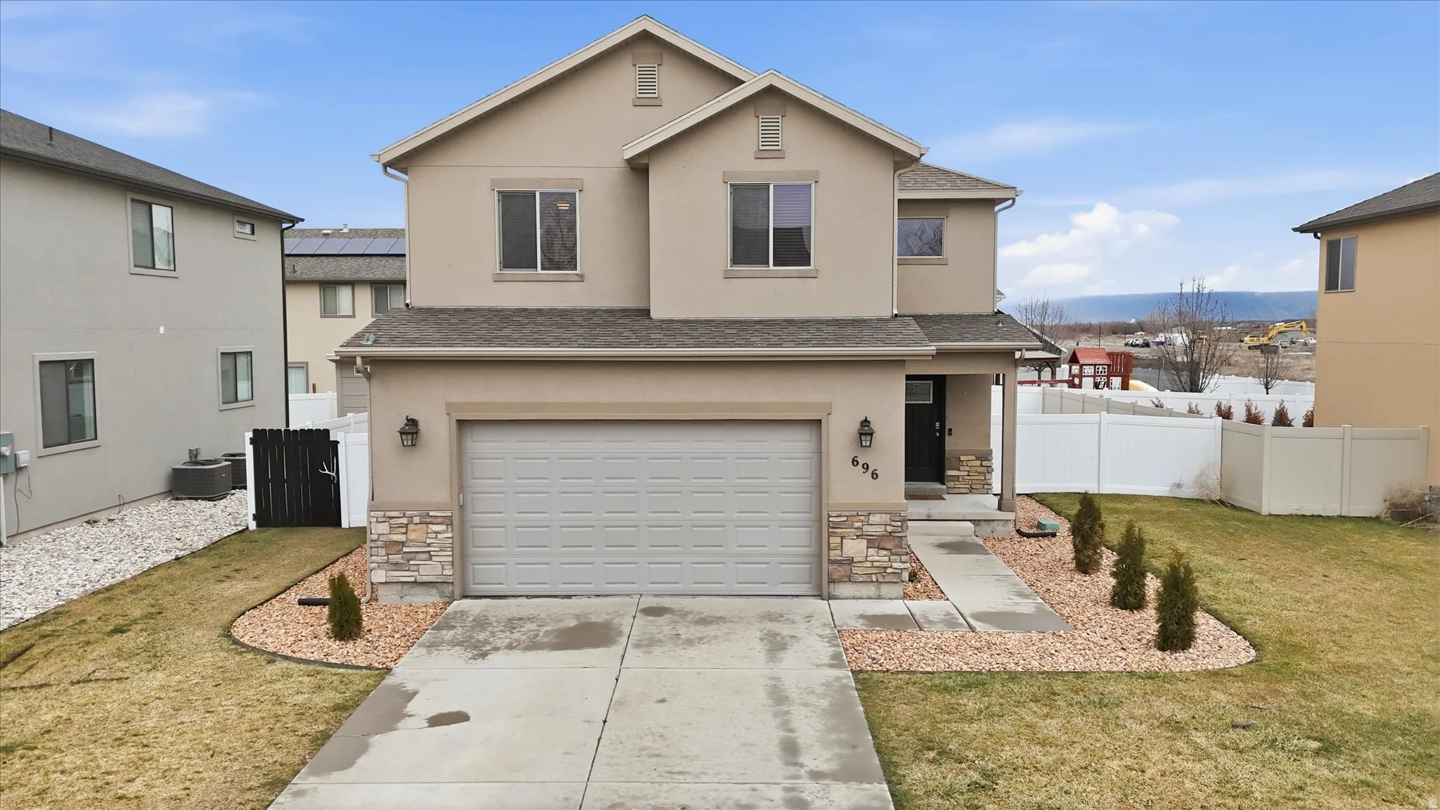Traditional-style home with stone siding, concrete driveway, and stucco siding