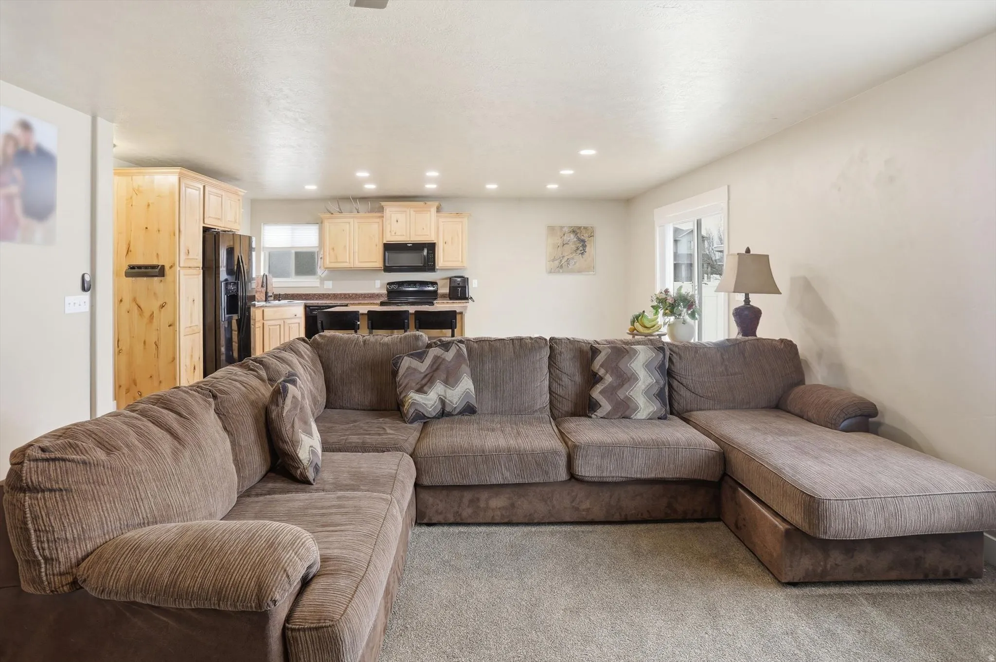 Living area with plenty of natural light, carpet, and recessed lighting