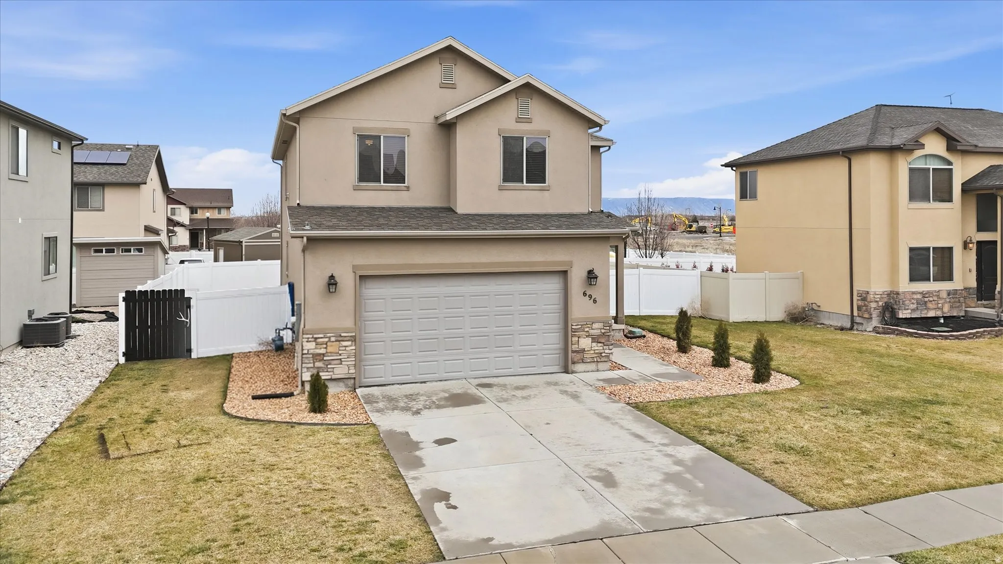 Traditional home with stone siding, stucco siding, and concrete driveway