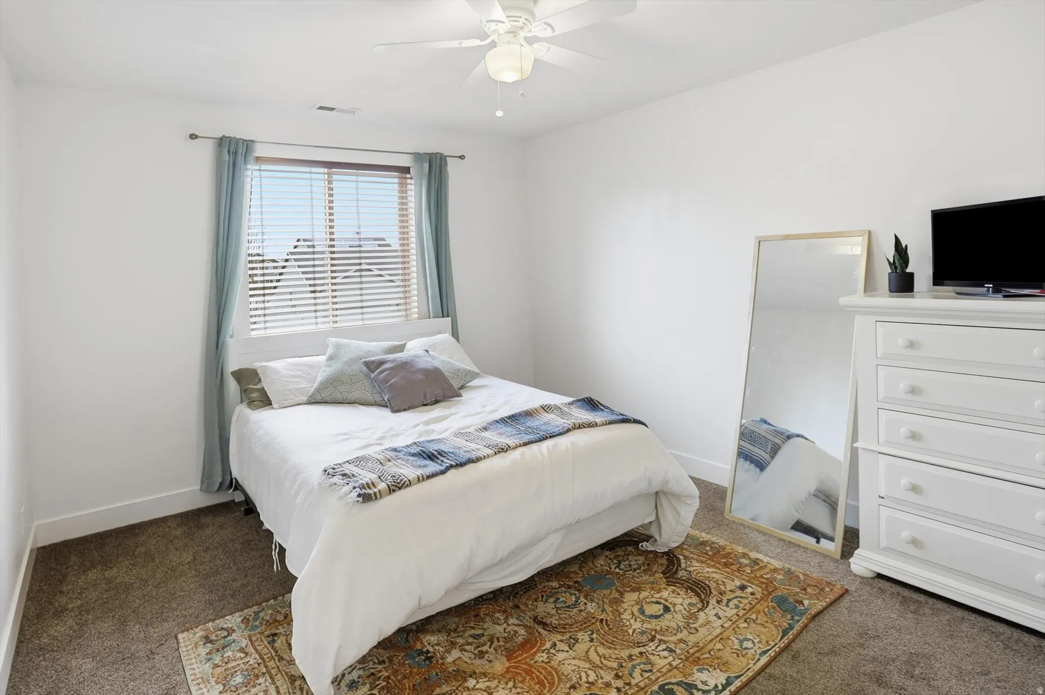 Bedroom with dark carpet and ceiling fan