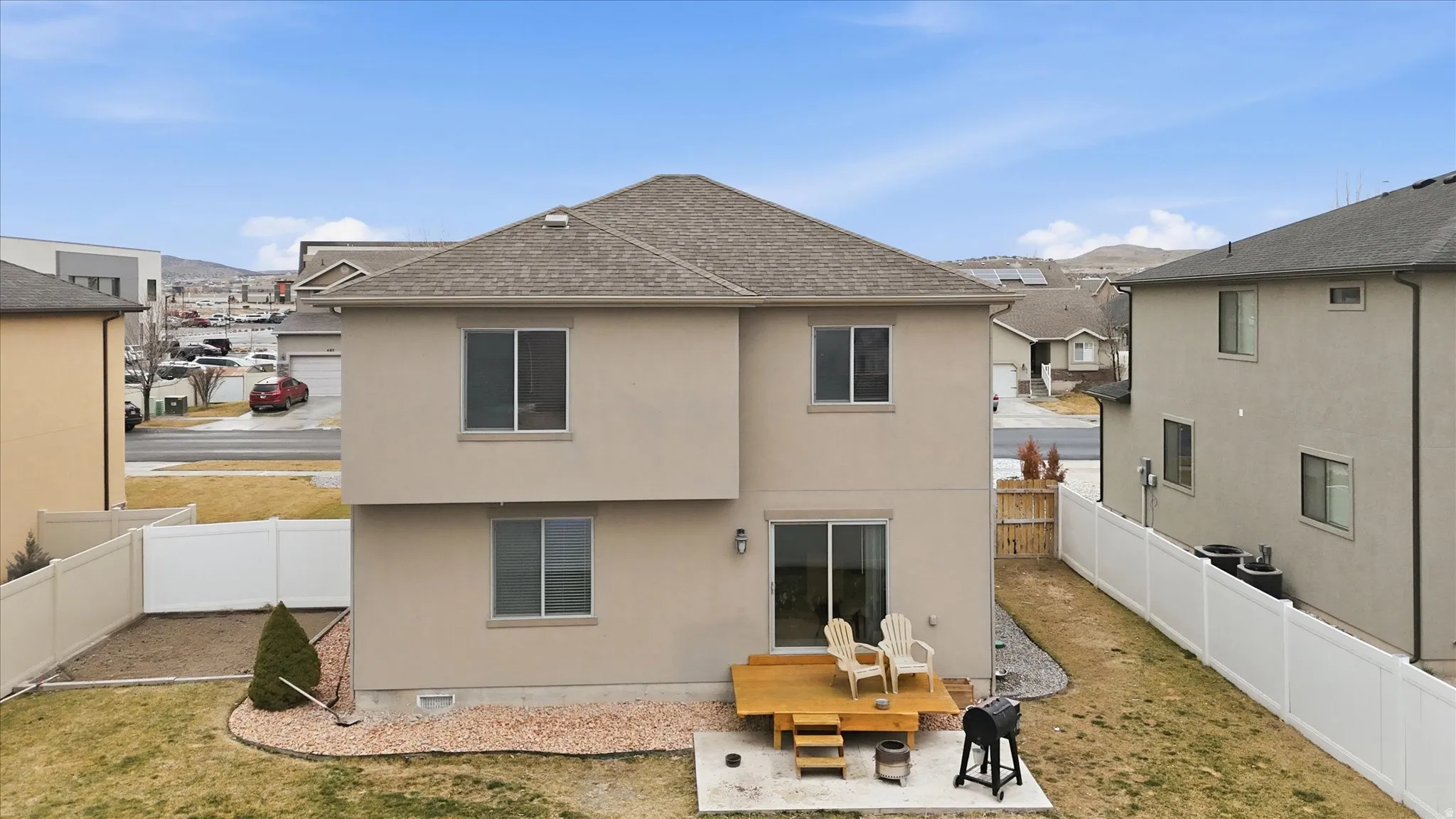 Rear view of house with a fenced backyard, a patio area, a shingled roof, and stucco siding