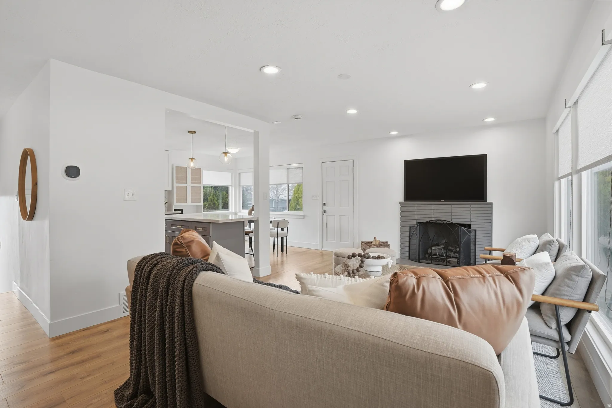 Living area with light wood-style flooring, a fireplace, and recessed lighting