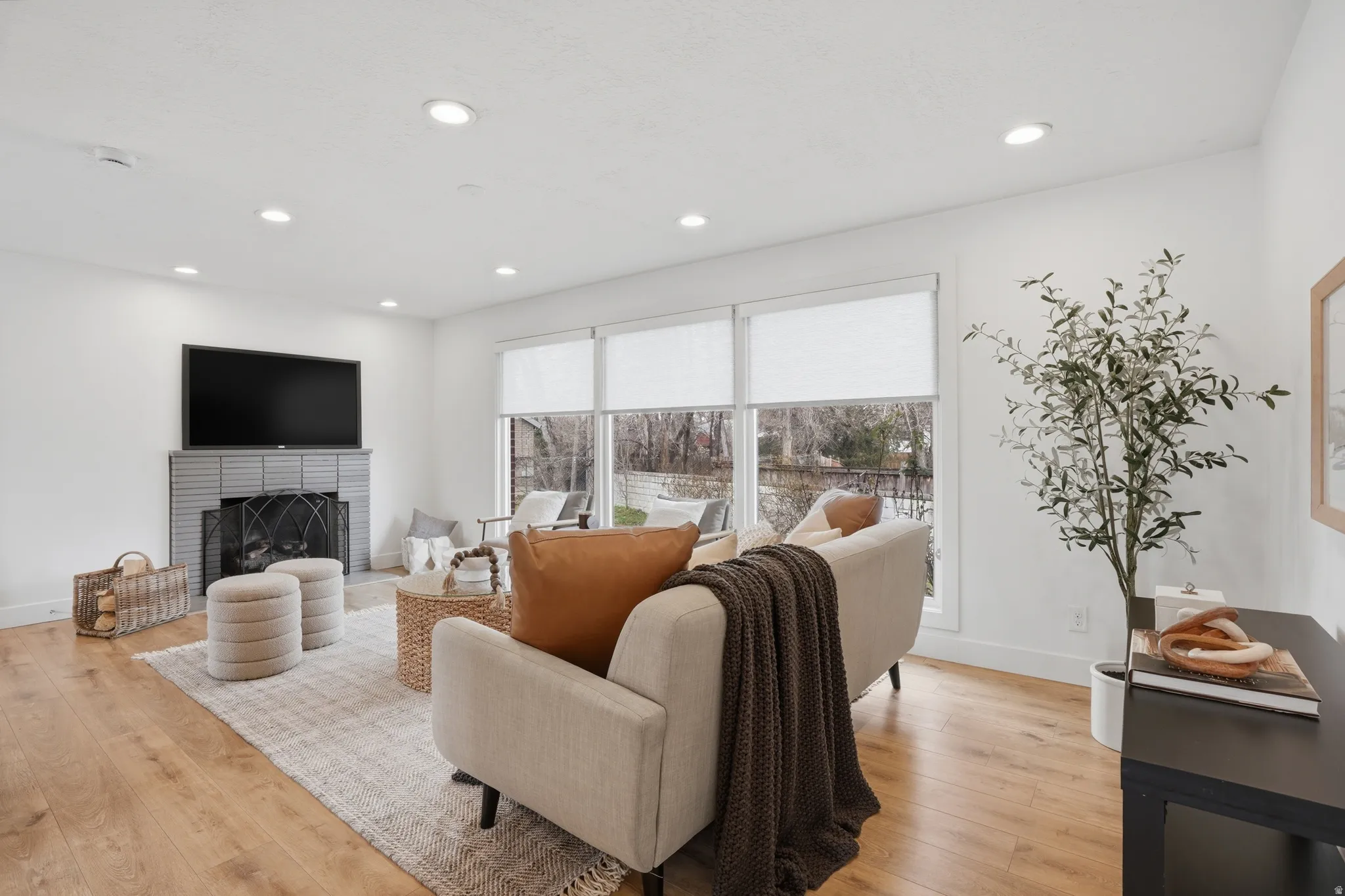Living area featuring light wood finished floors, a fireplace, and recessed lighting