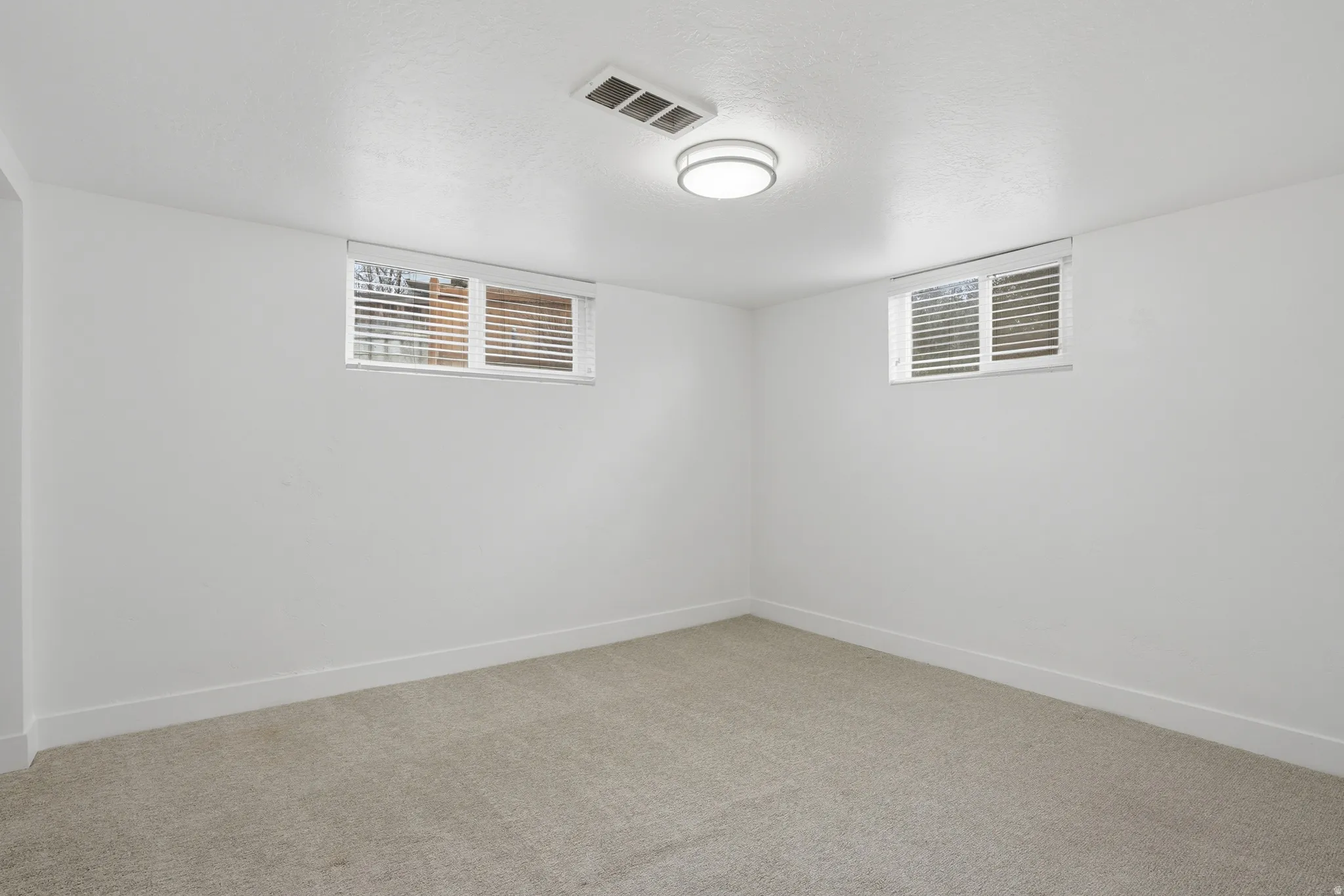 Basement bedroom featuring carpet flooring and a textured ceiling