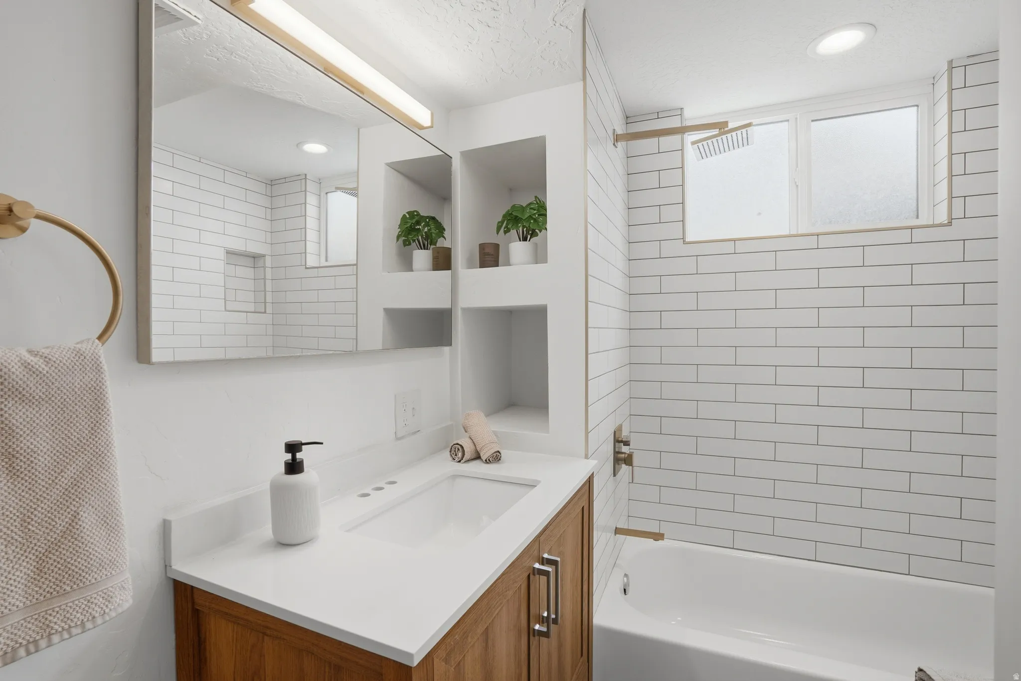 Downstairs Full bathroom featuring vanity, shower / bathtub combination, and a textured ceiling