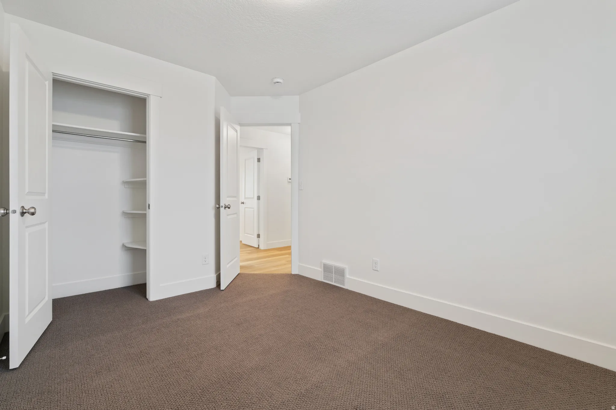 Unfurnished bedroom with dark colored carpet and a closet