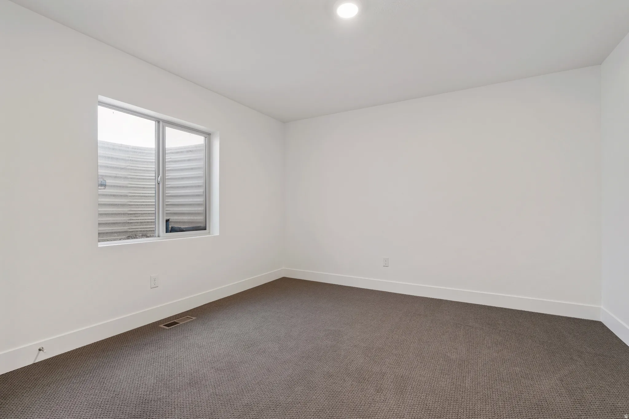 Unfurnished room with dark carpet and baseboards