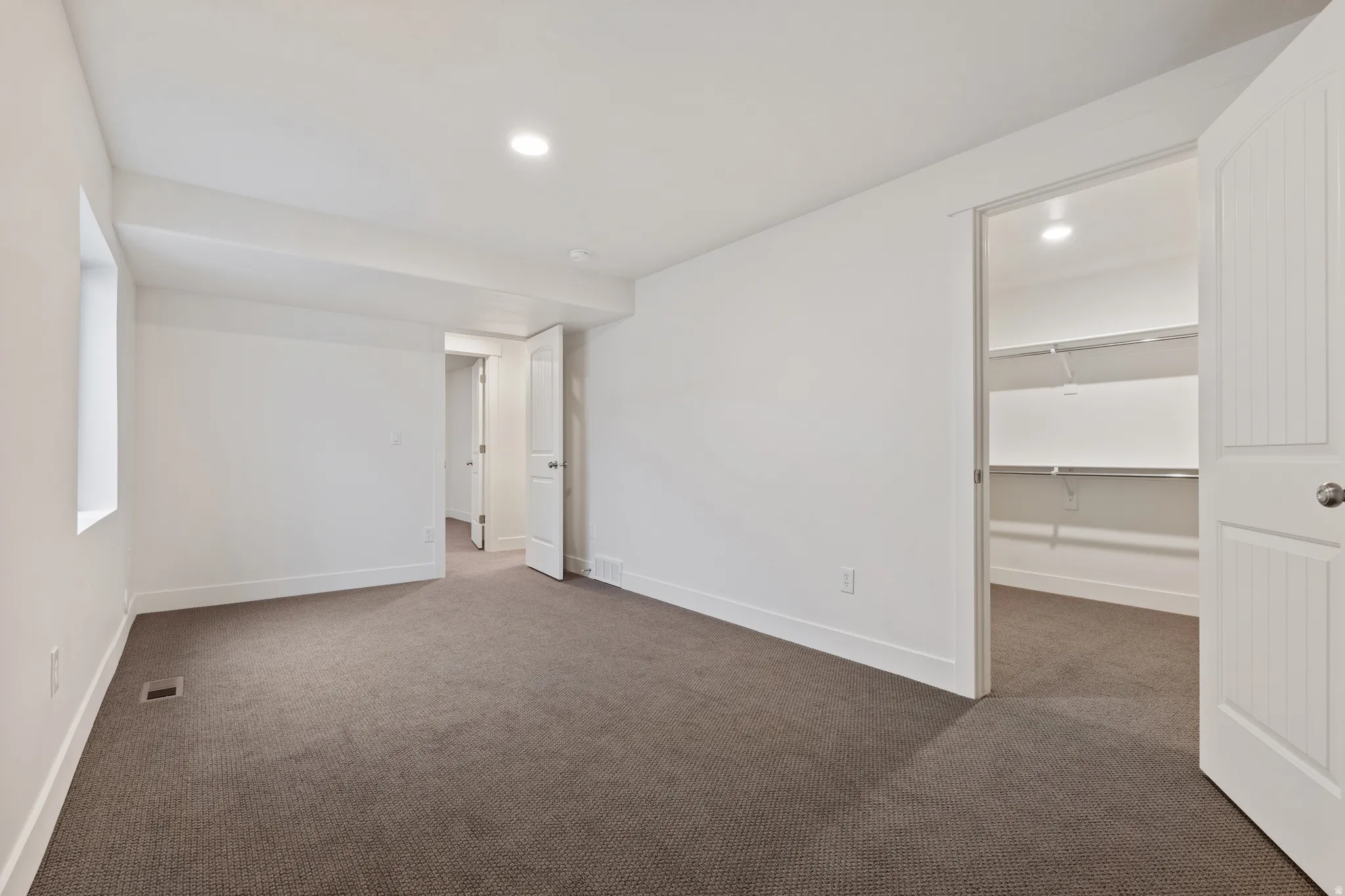 Empty room featuring dark carpet and recessed lighting