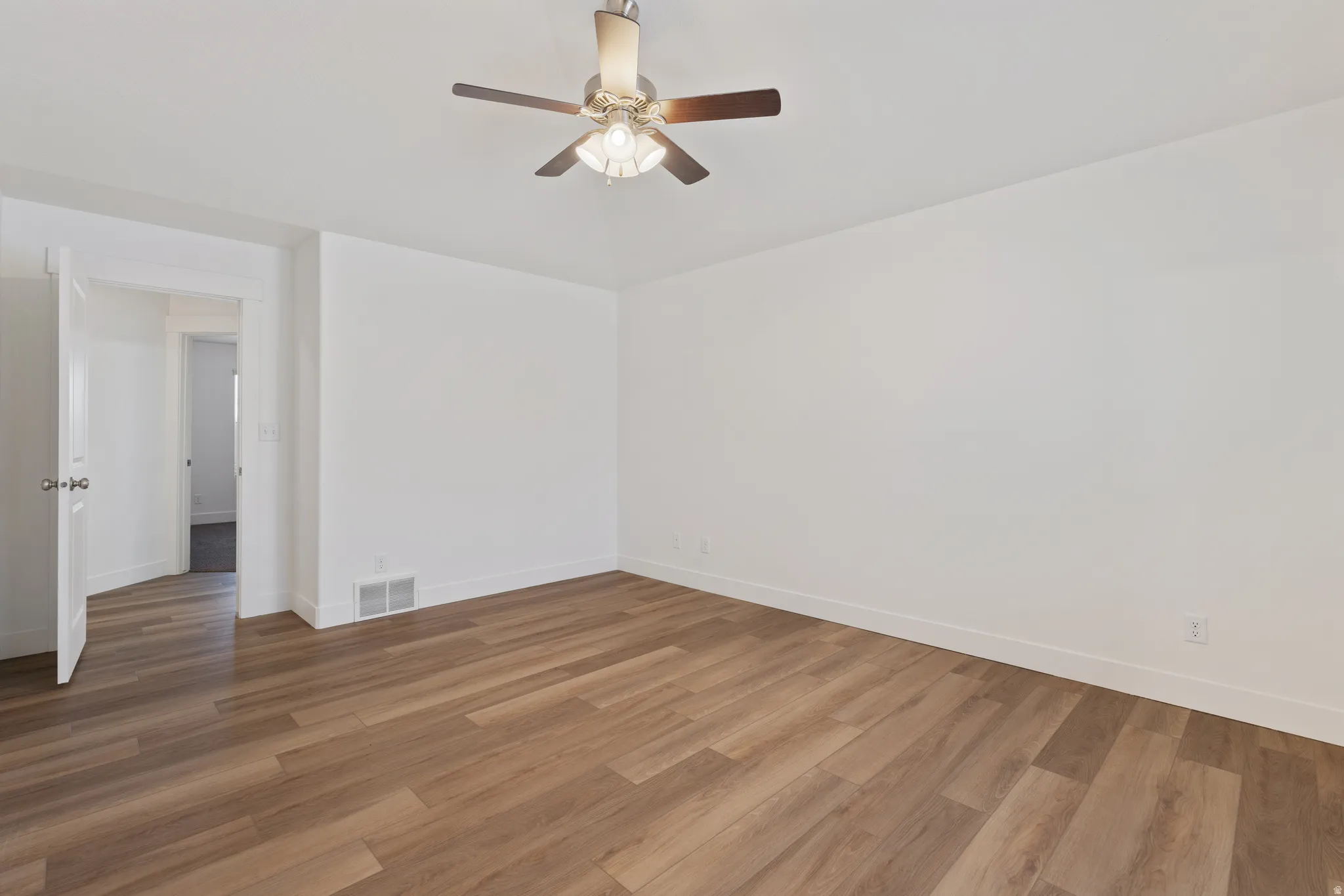 Empty room featuring a ceiling fan and wood finished floors