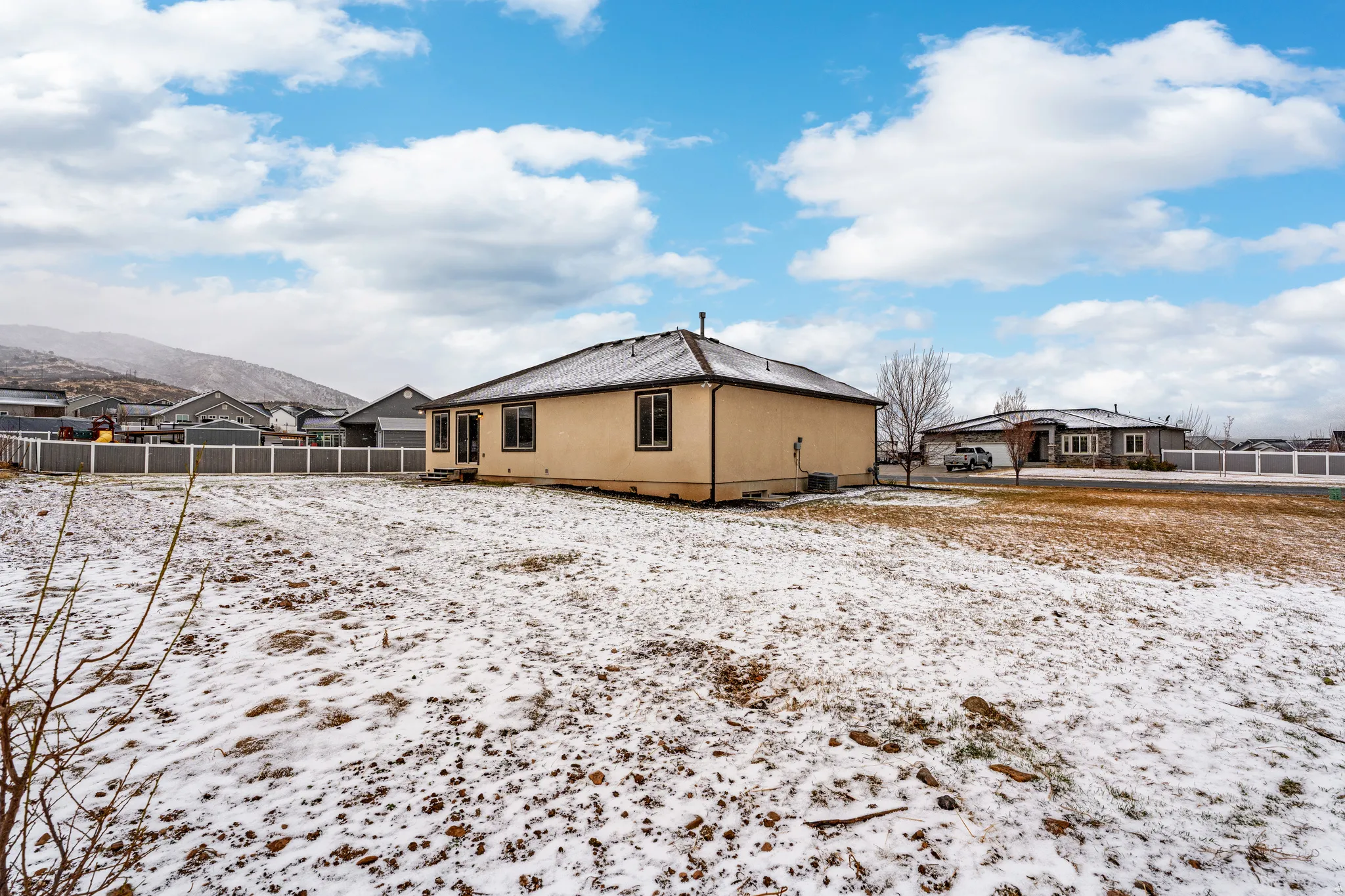 Snow covered house featuring a residential view and a mountain view