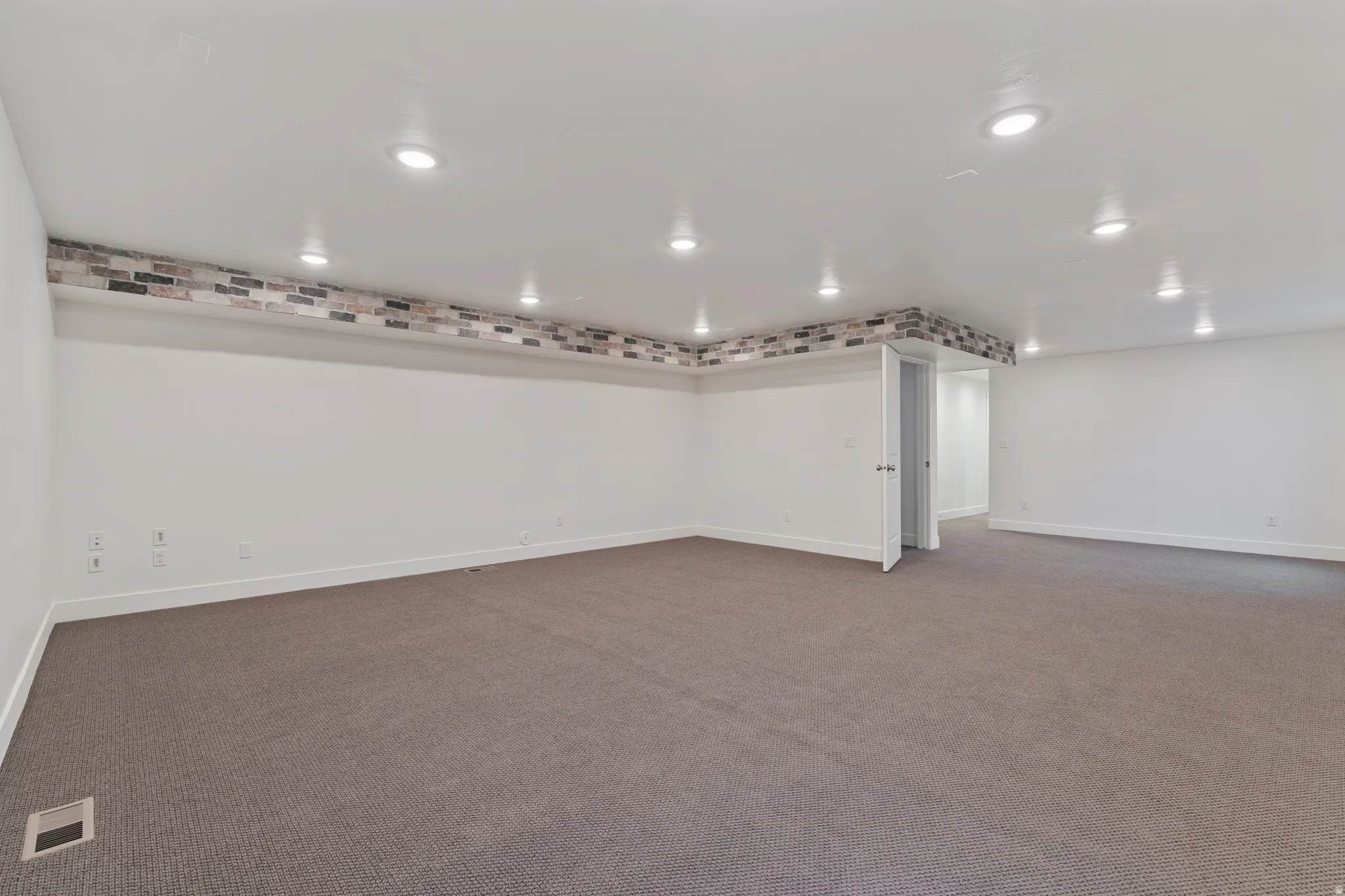 Below grade area with dark colored carpet and recessed lighting