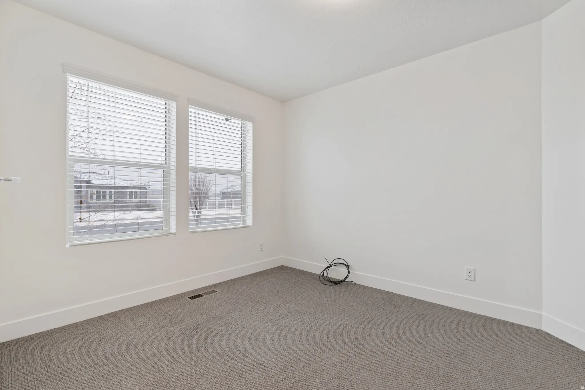 Carpeted empty room featuring baseboards