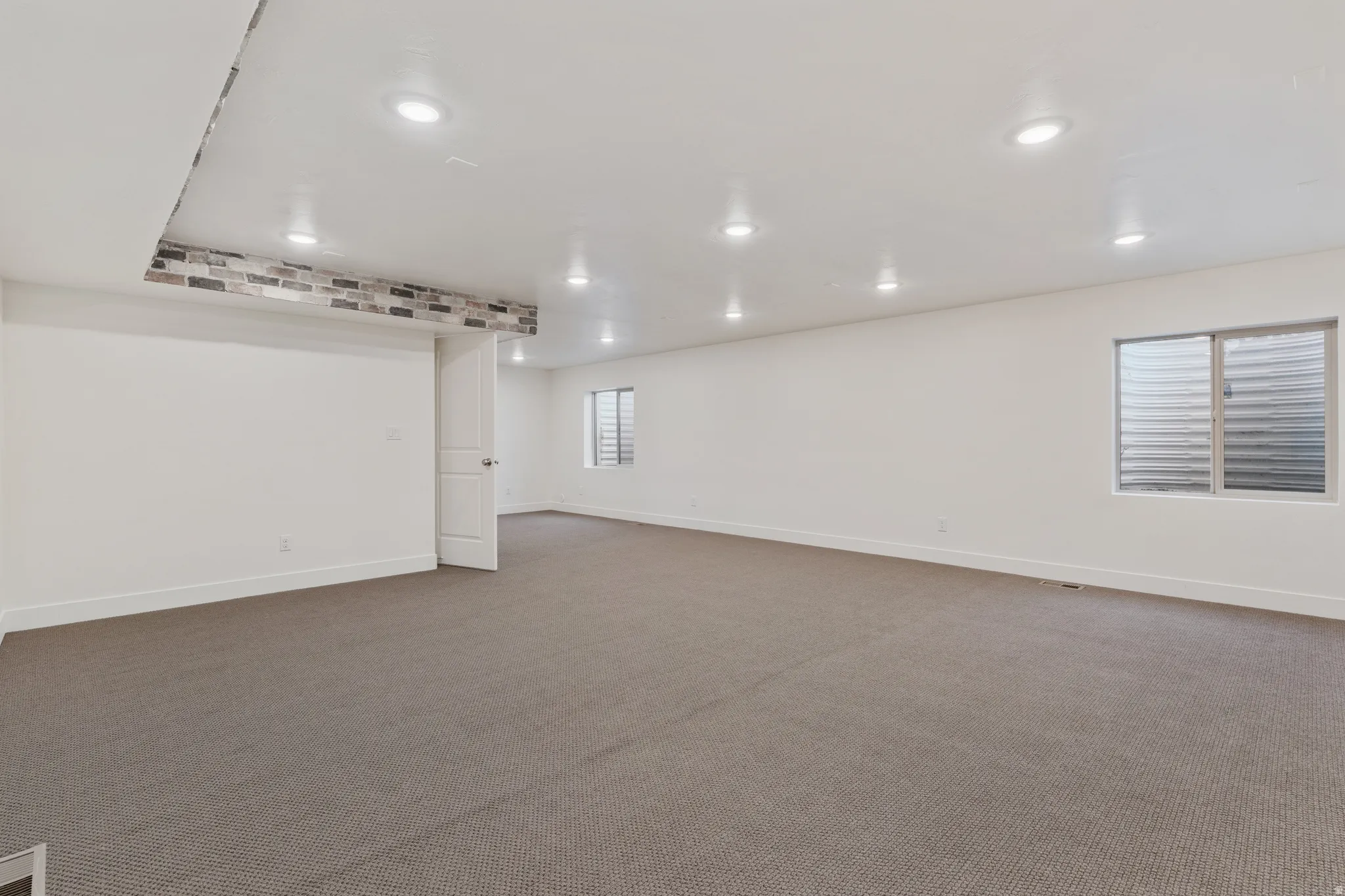 Basement featuring dark colored carpet and recessed lighting