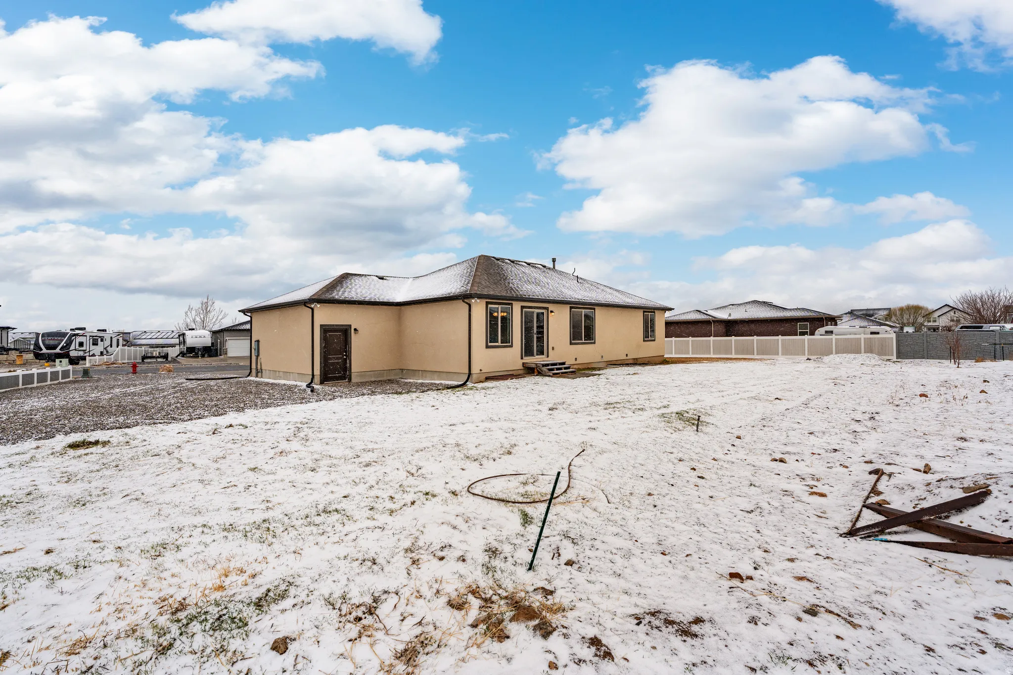 Snow covered rear of property with stucco siding