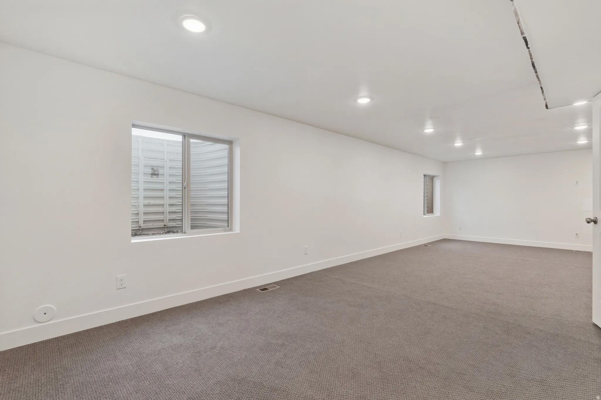 Basement featuring dark carpet and recessed lighting