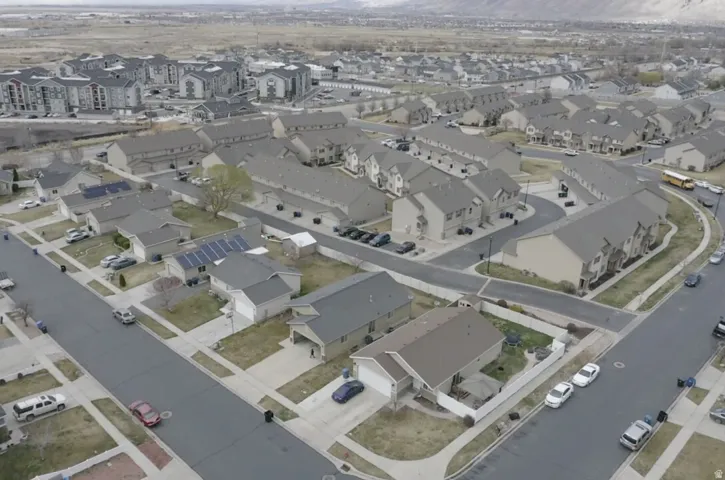 Aerial view of property and surrounding area featuring nearby suburban area