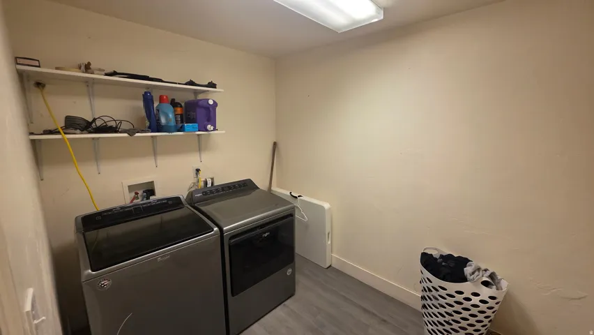 Laundry room featuring wood finished floors and washer and dryer