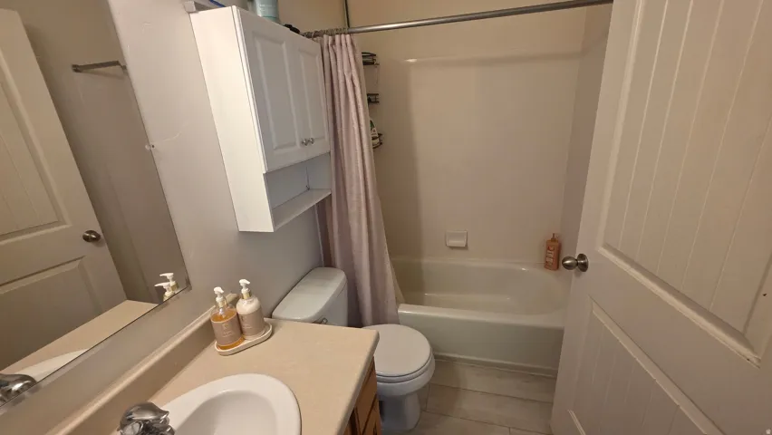 Full bathroom featuring vanity and shower / bath combination with curtain