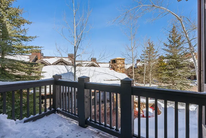 Snow covered deck featuring a balcony