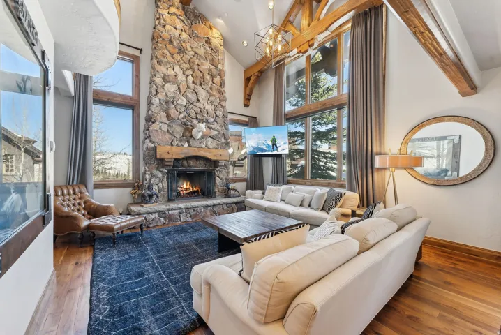 Living area with vaulted ceiling, a fireplace, hardwood / wood-style floors, and healthy amount of natural light