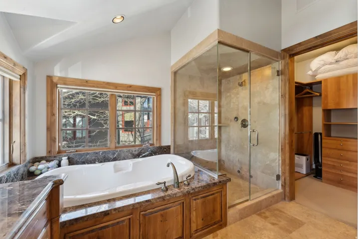 Full bath featuring a shower stall, vaulted ceiling, a bath, recessed lighting, and vanity