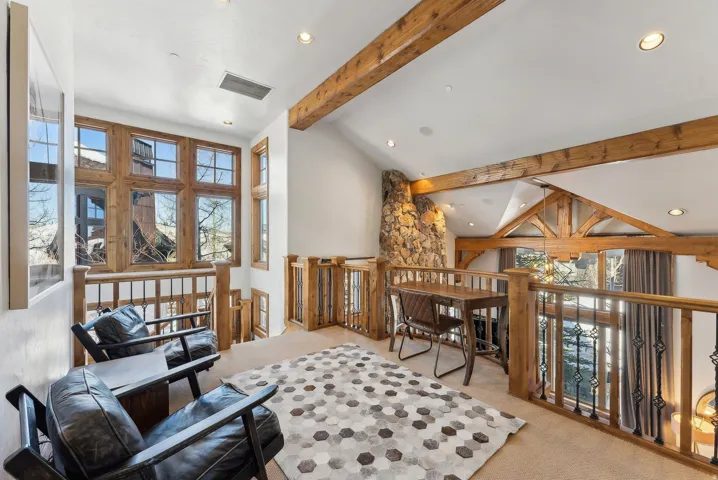 Sitting room featuring light colored carpet, vaulted ceiling, recessed lighting, and an upstairs landing