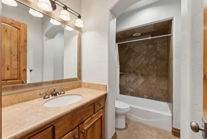 Bathroom featuring vanity, shower / tub combo, and light tile patterned flooring