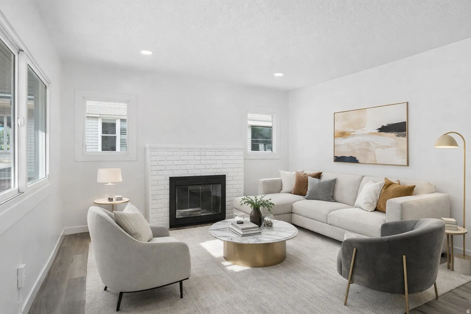 Living area with a brick fireplace, wood finished floors, and recessed lighting