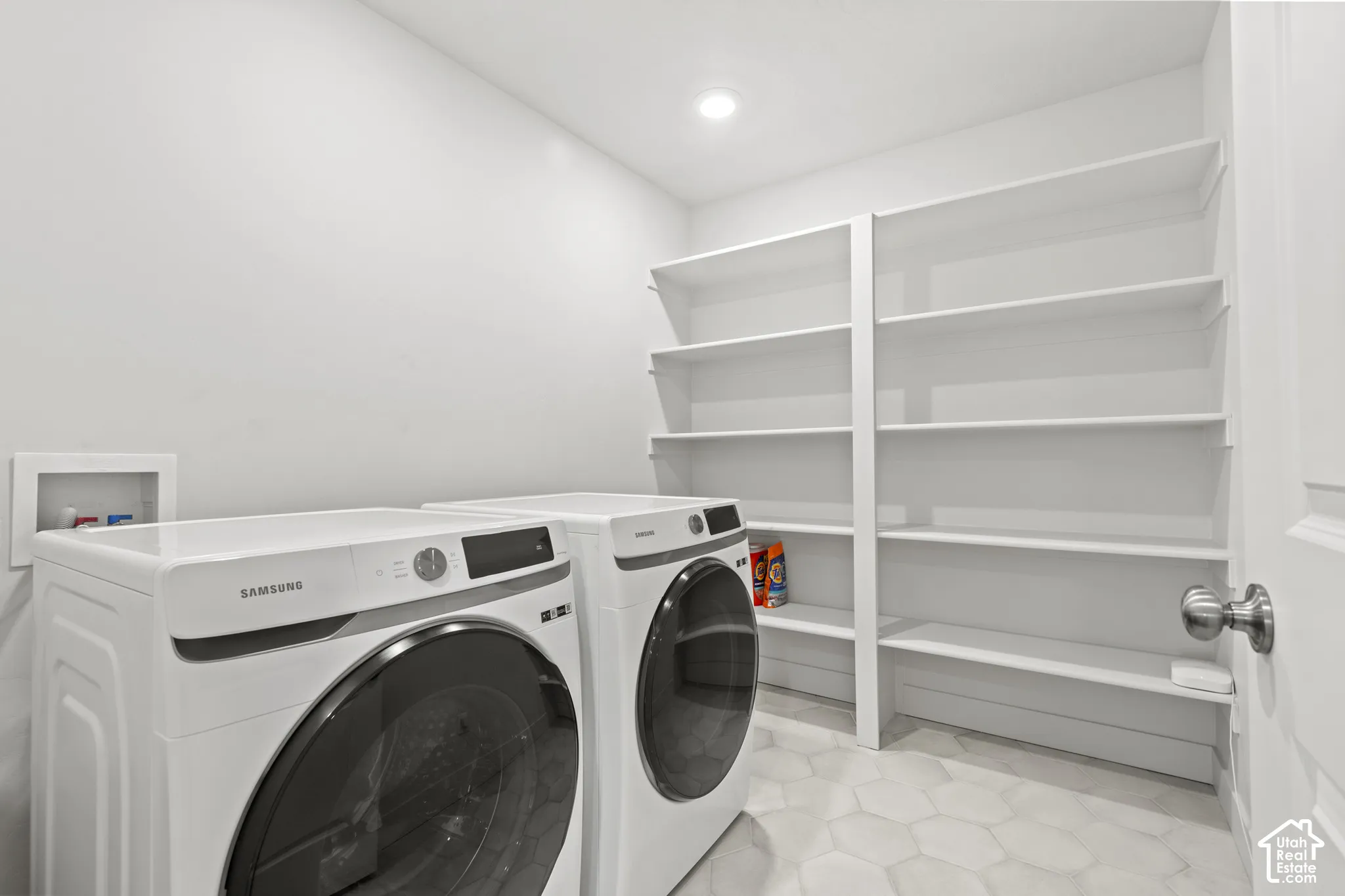 Laundry area featuring washer and dryer, built in shelving, and recessed lighting