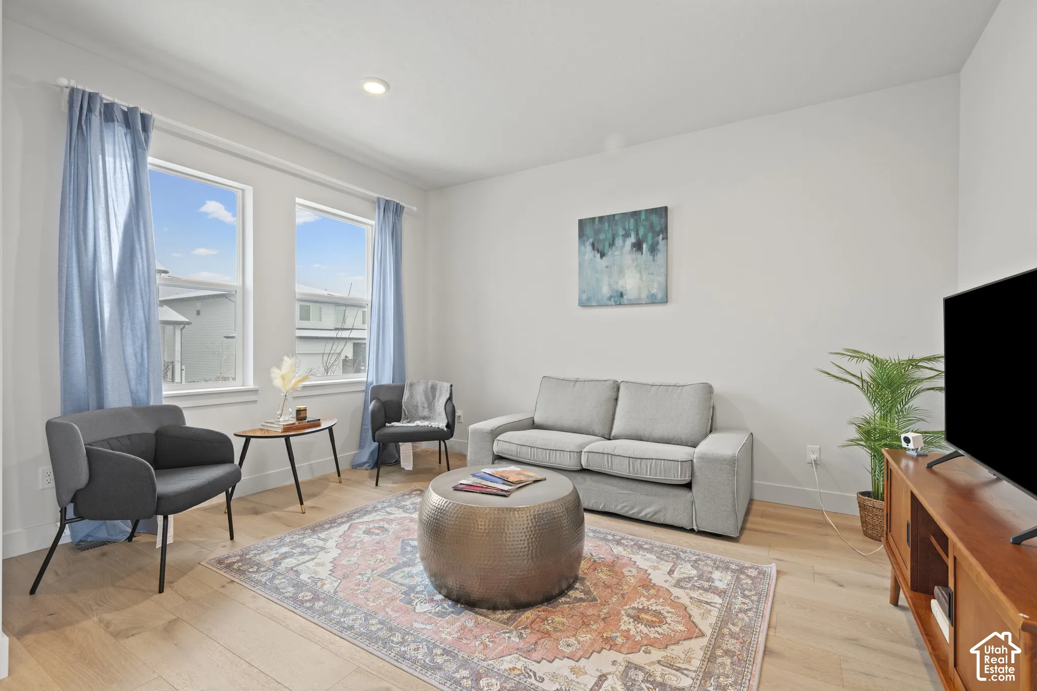 Formal living room off of entry featuring light wood LVP floors and recessed lighting