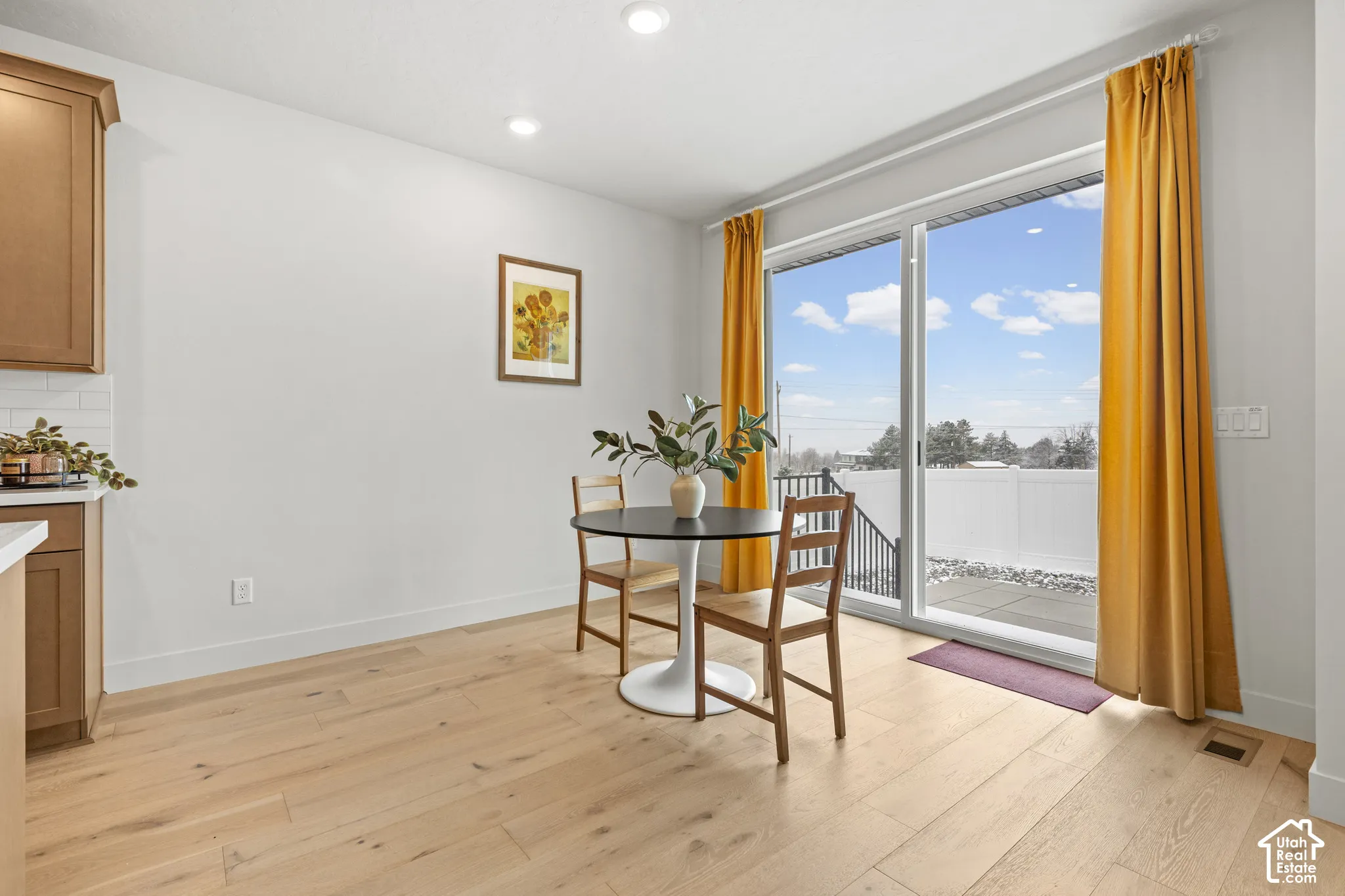 Dining room with light LVP wood flooring, large sliding glass window, and recessed lighting