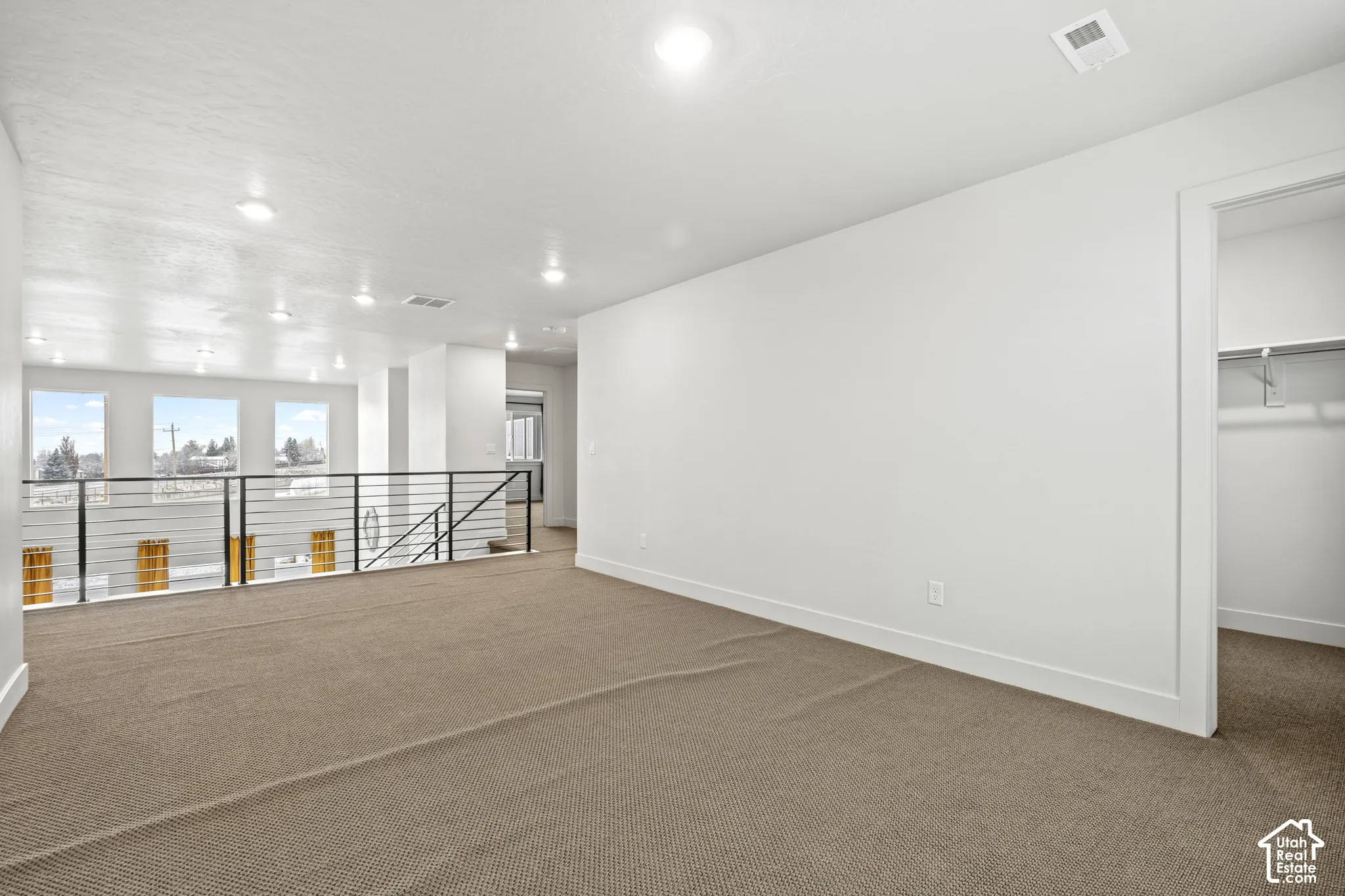 Bonus loft area featuring light colored carpet and recessed lighting