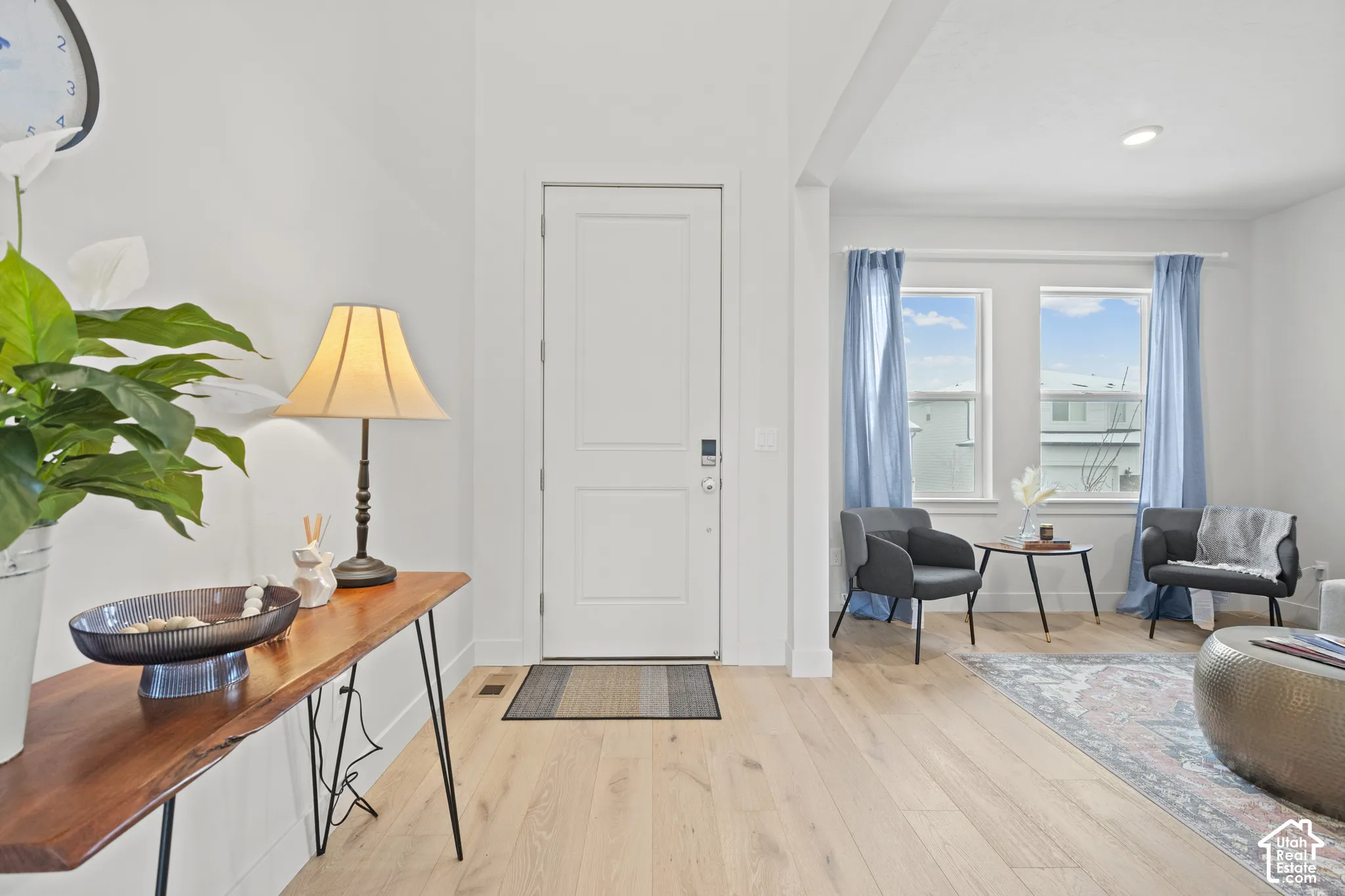 Formal living room off of entry featuring light wood LVP floors and recessed lighting