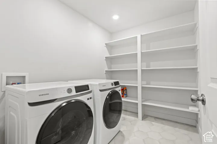 Laundry area featuring washer and dryer, built in shelving, and recessed lighting