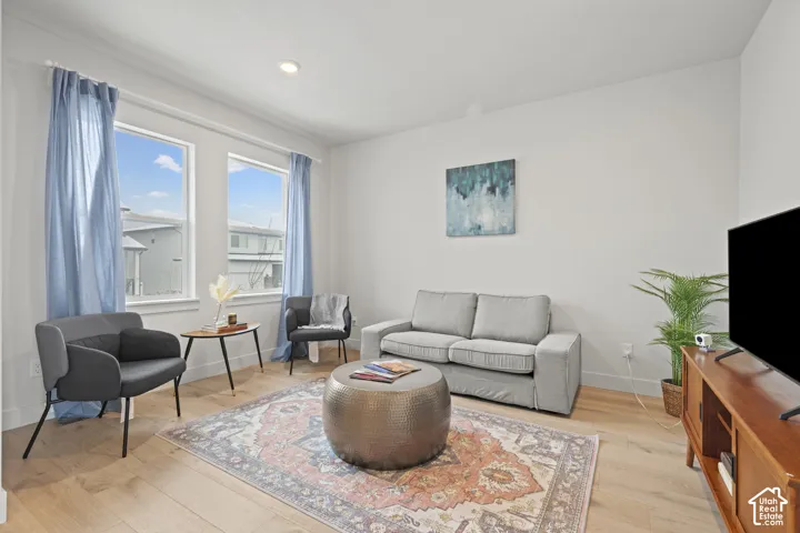 Formal living room off of entry featuring light wood LVP floors and recessed lighting