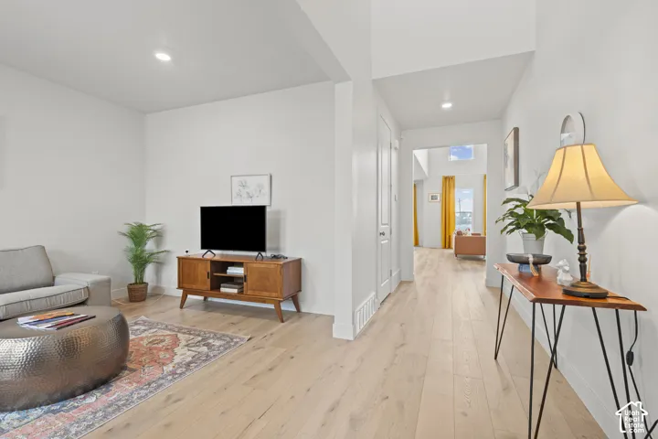 Formal living room off of entry featuring light wood LVP floors and recessed lighting