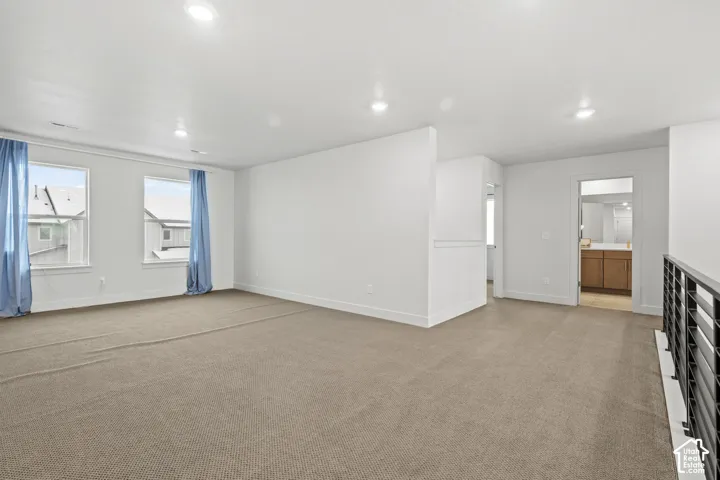 Bonus loft area featuring light colored carpet and recessed lighting