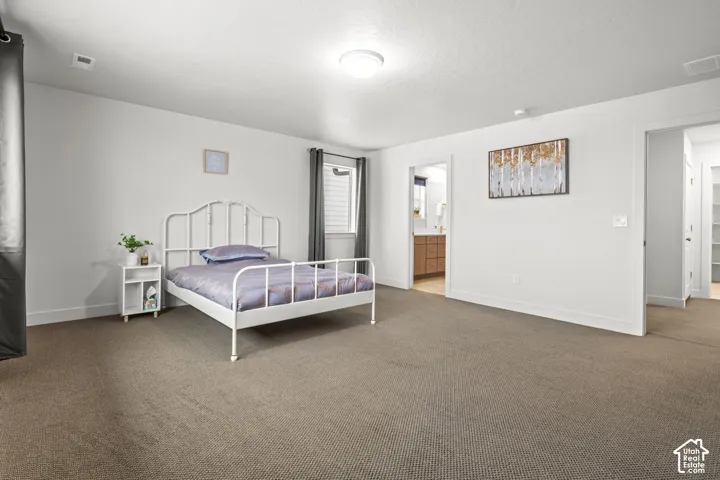 Carpeted bedroom with baseboards and ensuite bathroom
