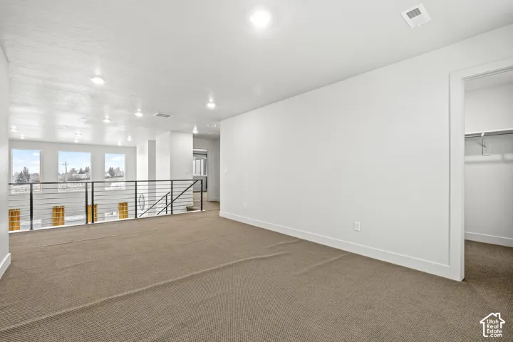 Bonus loft area featuring light colored carpet and recessed lighting