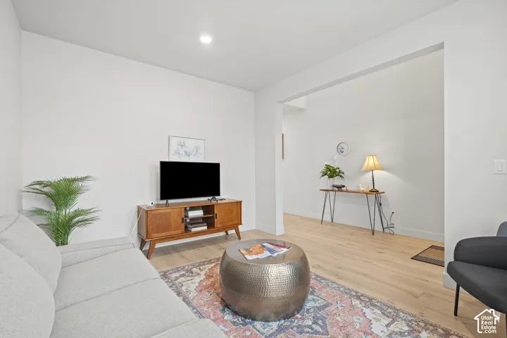 Formal living room off of entry featuring light wood LVP floors and recessed lighting