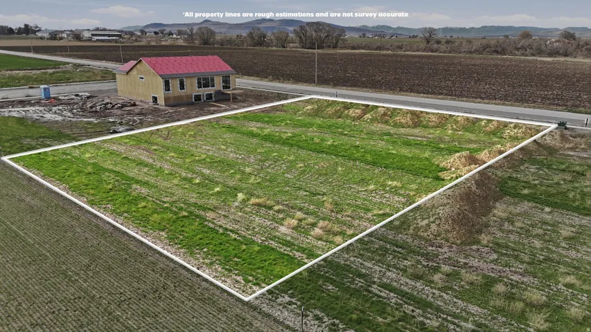 Aerial view of sparsely populated area featuring rows of crops and mountains