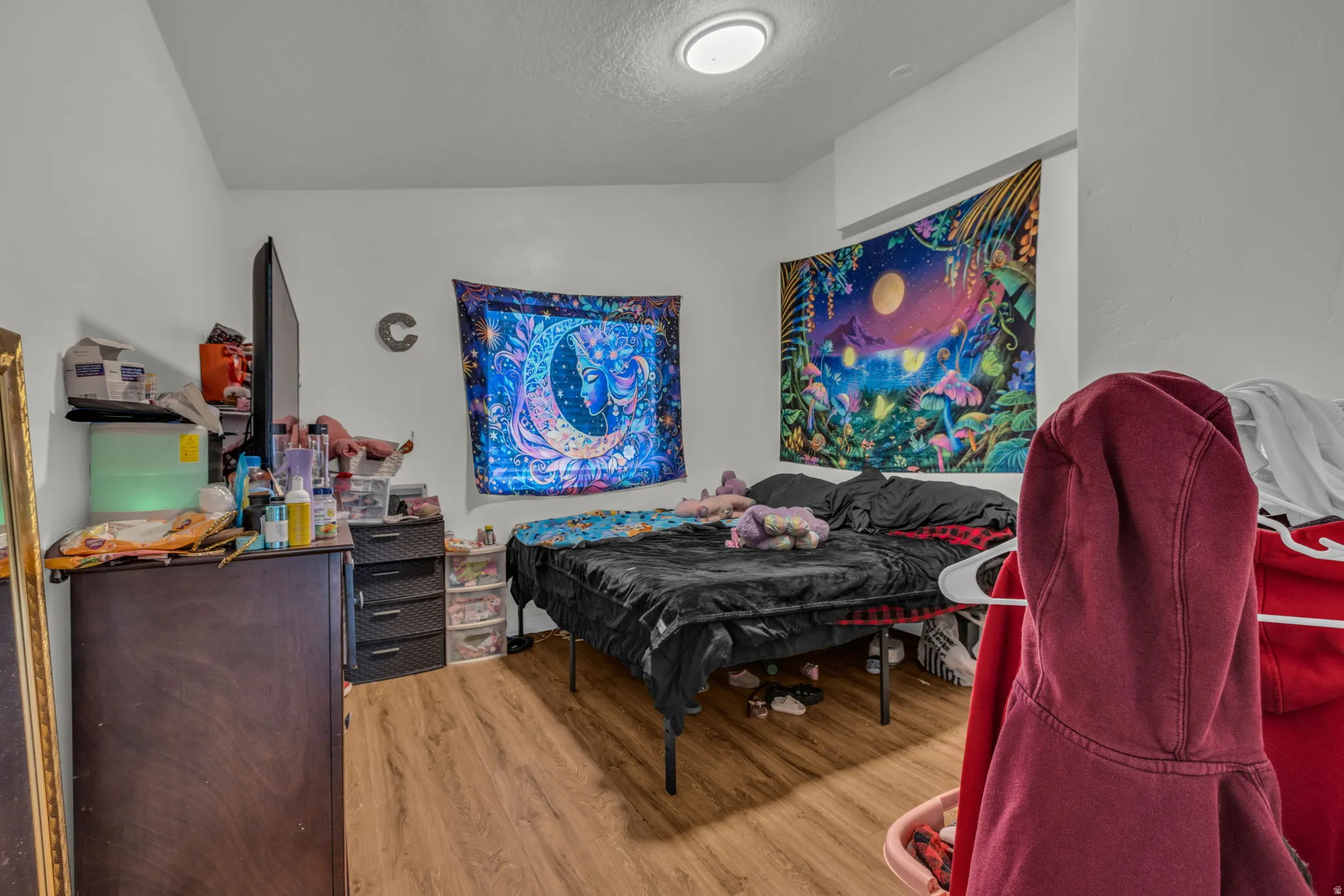 Bedroom with light wood-style floors and a textured ceiling