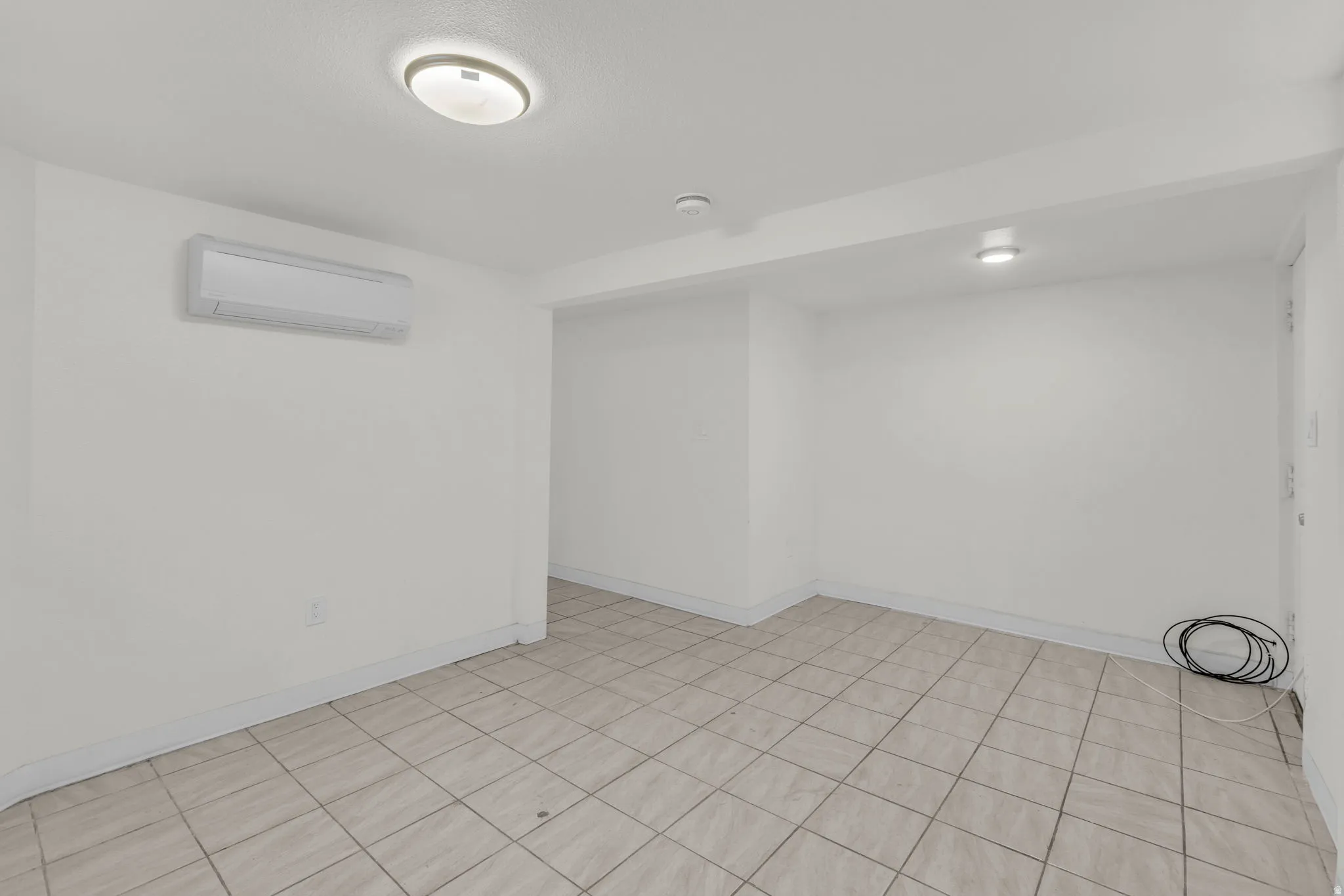 Unfurnished room featuring a mini split for heating / cooling and baseboards